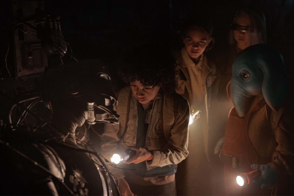  (L-R): SM-33 (gesprochen von Nick Frost), Wim (Ravi Cabot-Conyers), Fern (Ryan Kiera Armstrong), KB (Kyriana Kratter) und Neel (Robert Timothy Smith) in einer dunklen Umgebung.
Bild: Matt Kennedy/Lucasfilm 